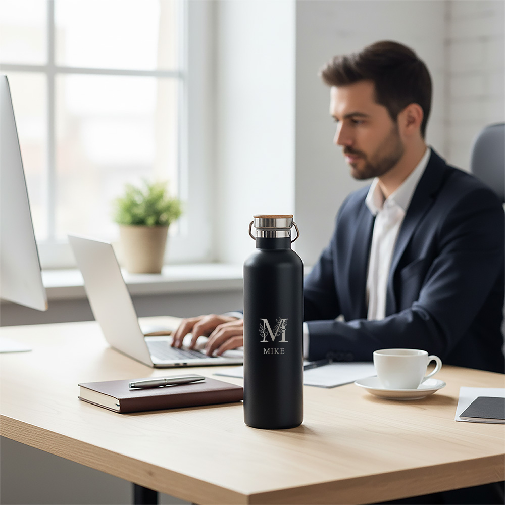 Thermosfles zwart graveren Personalsurprise sfeer foto 2 | Gepersonaliseerde cadeaus Gegraveerde zwarte thermosfles met naam op een bureau